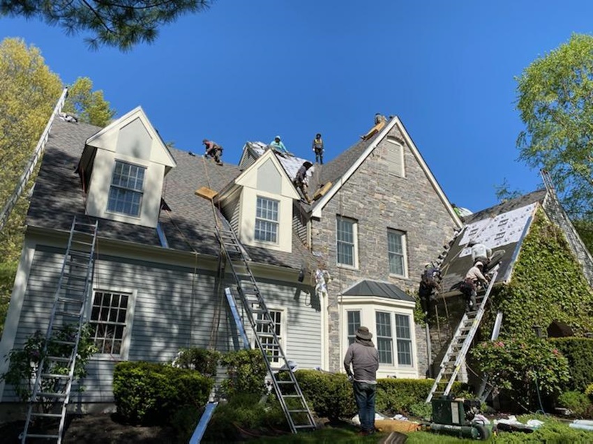 Roof Repairmen Working Together On A Sunny Afternoon