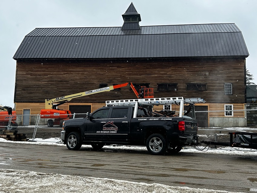 A Truck Parked In Front Of A Wooden Barn