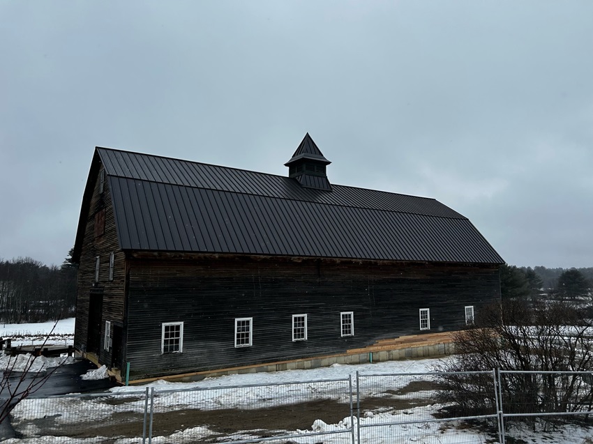 A Barn With A Black And Metal Roof