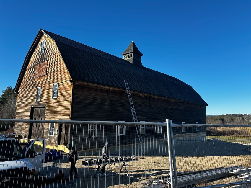 A Spacious Barn With A Vast Roof And A Surrounding Fence