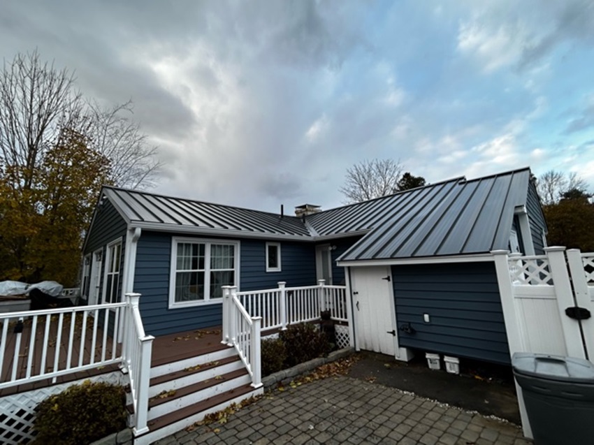 A Blue House With A Metal Roof